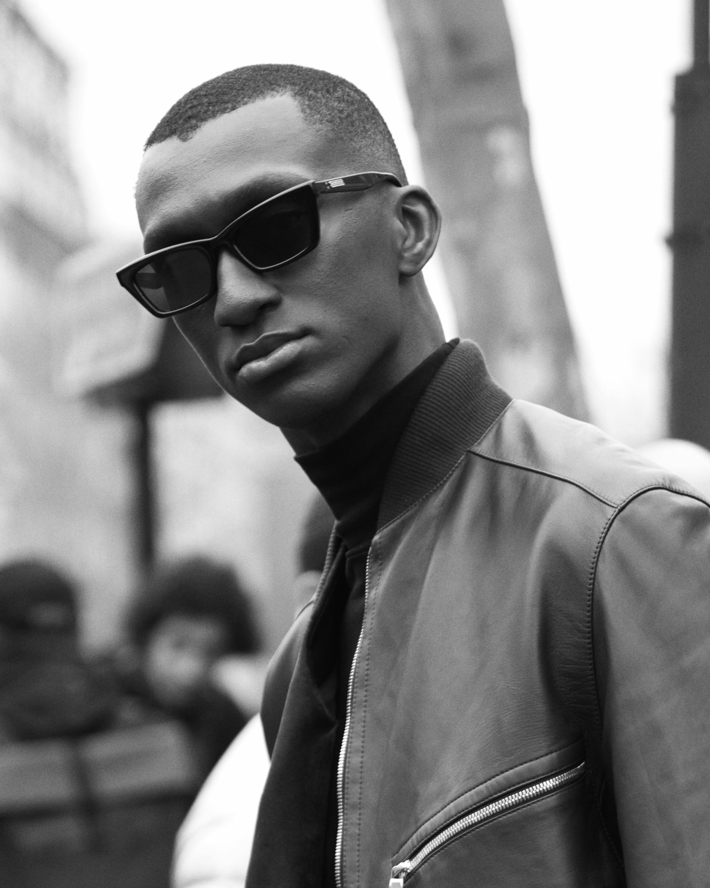 Free Elegant black and white portrait of a man in Paris, epitomizing contemporary street fashion. Stock Photo