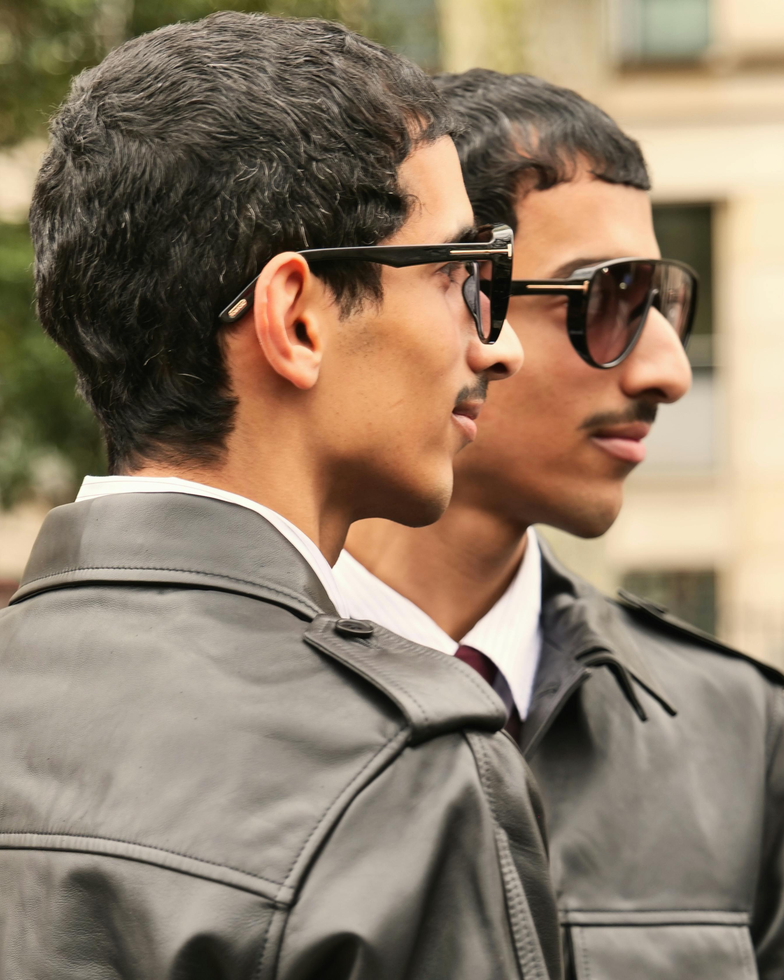 grátis Dois adultos elegantes usando óculos escuros e jaquetas de couro em Paris. Foto profissional