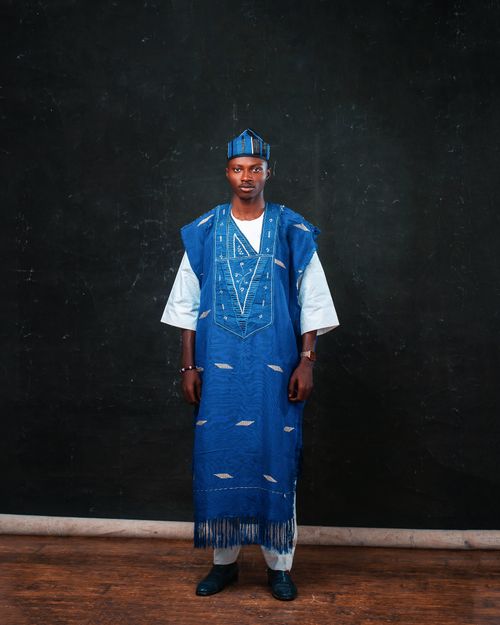 Free Portrait of a man in vibrant blue traditional African clothing indoors. Stock Photo