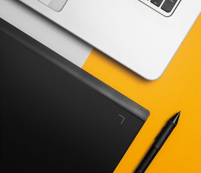 俯视彩色办公桌上的笔记本电脑和图形平板电脑