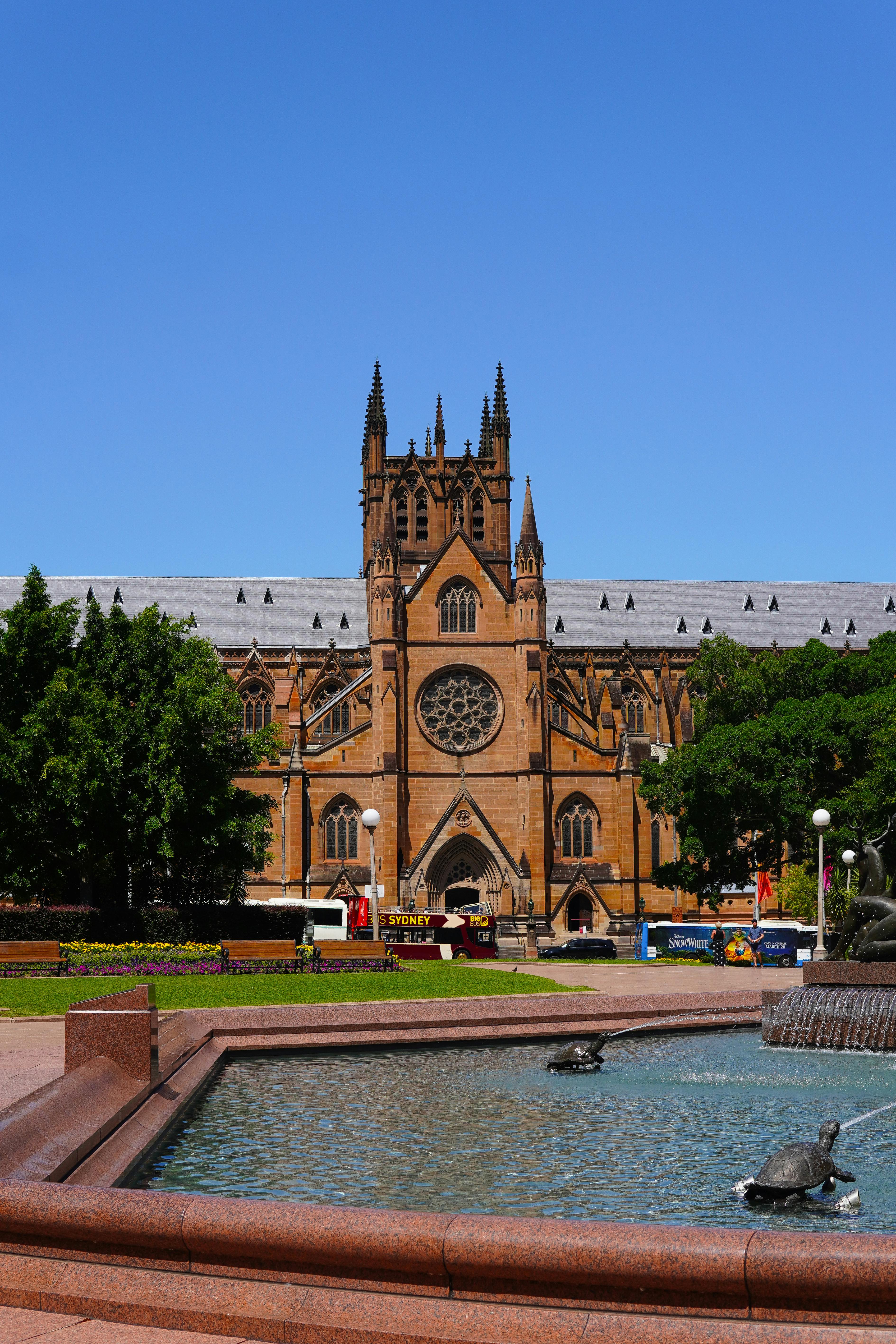View of St. Mary's Cathedral and a decorative fountain in Sydney, bright day.