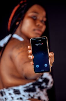 A person holding a smartphone displaying an incoming call with blurred background.