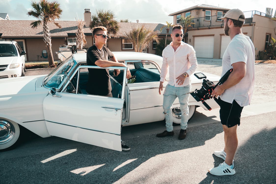 Standing Man Wearing White Dress Shirt Beside Two Men and White Sedan