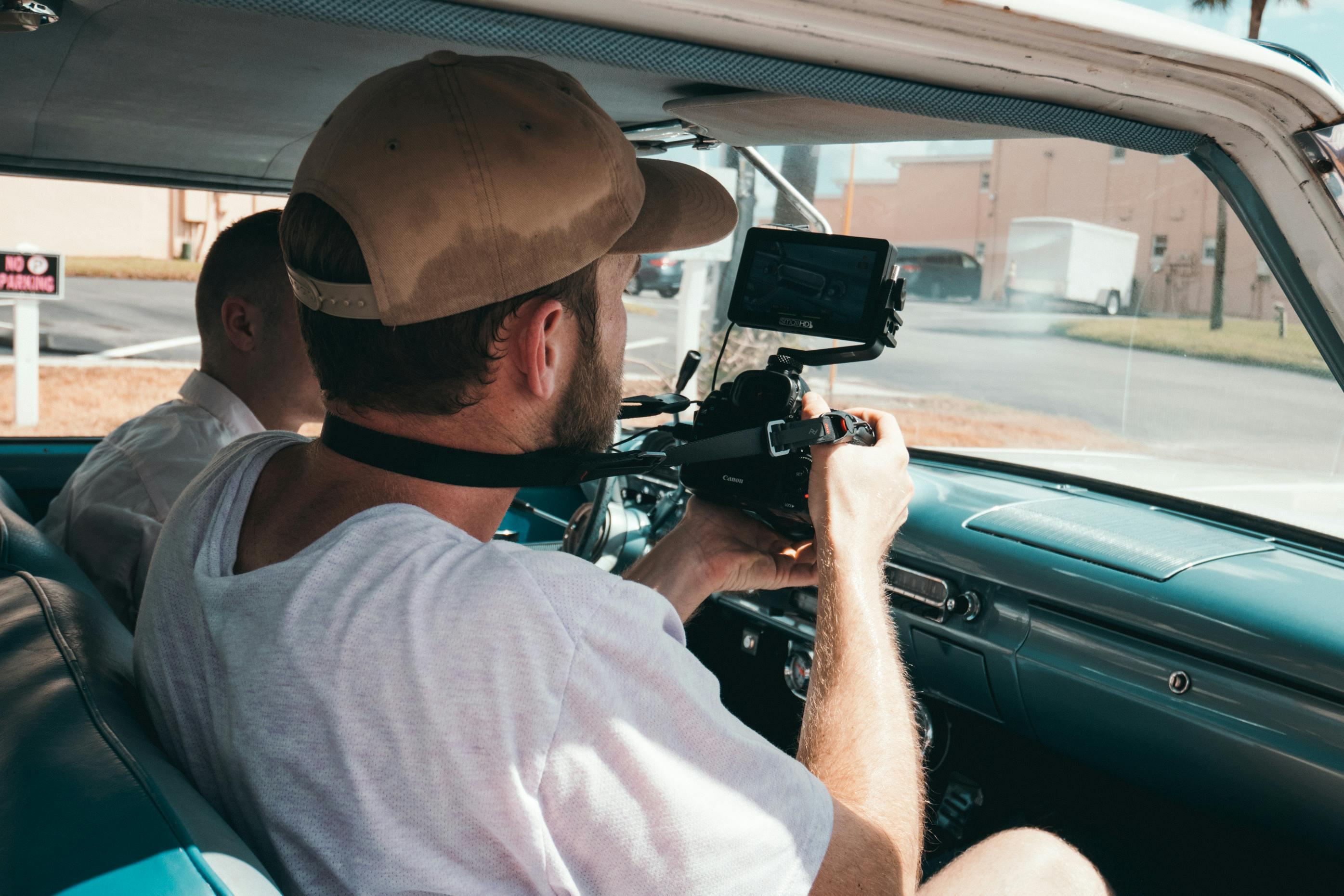A person holding a camera inside a car
