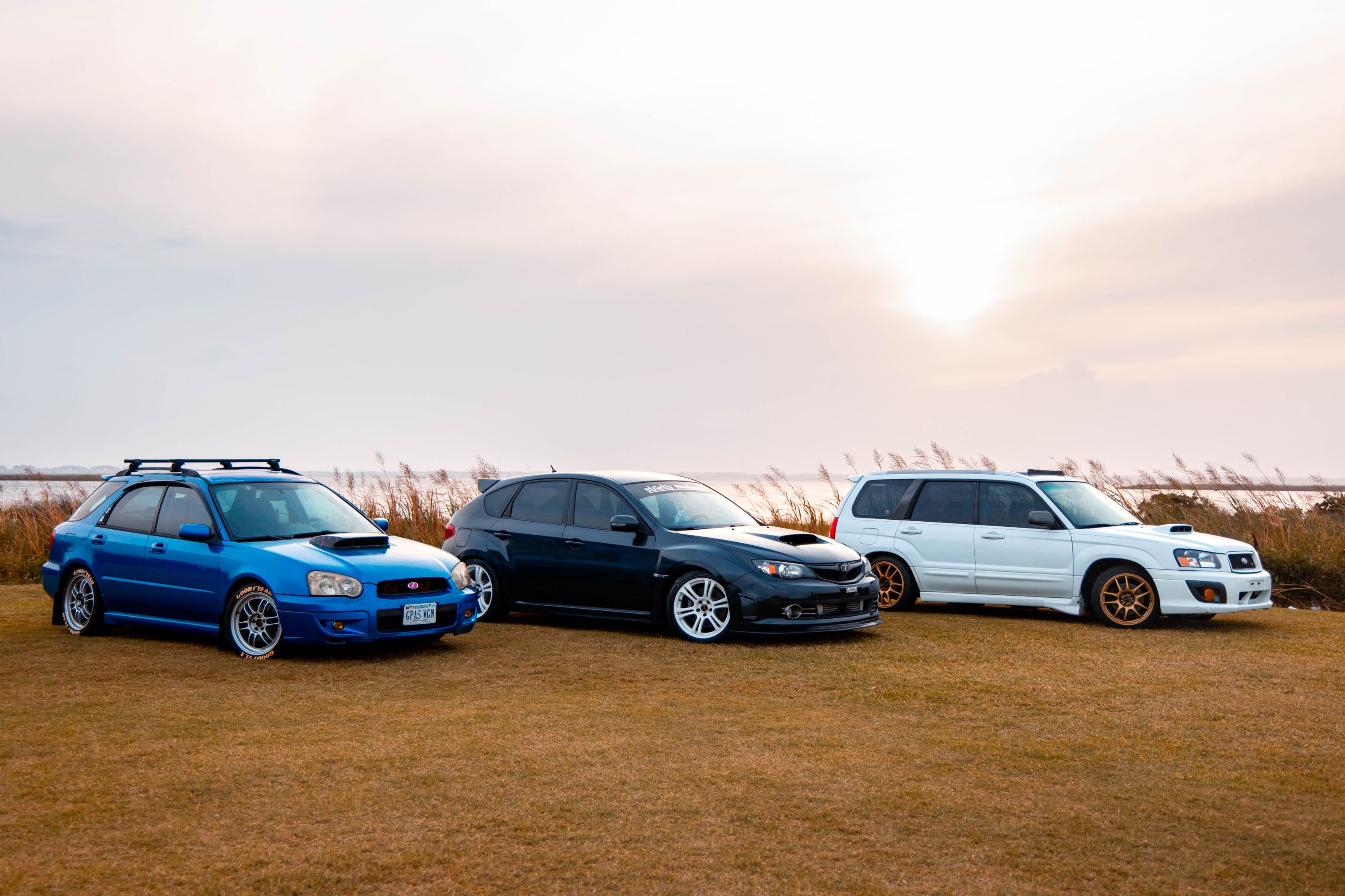 Three Subaru cars displayed outdoors at sunset, capturing the beauty and power of automotive design.