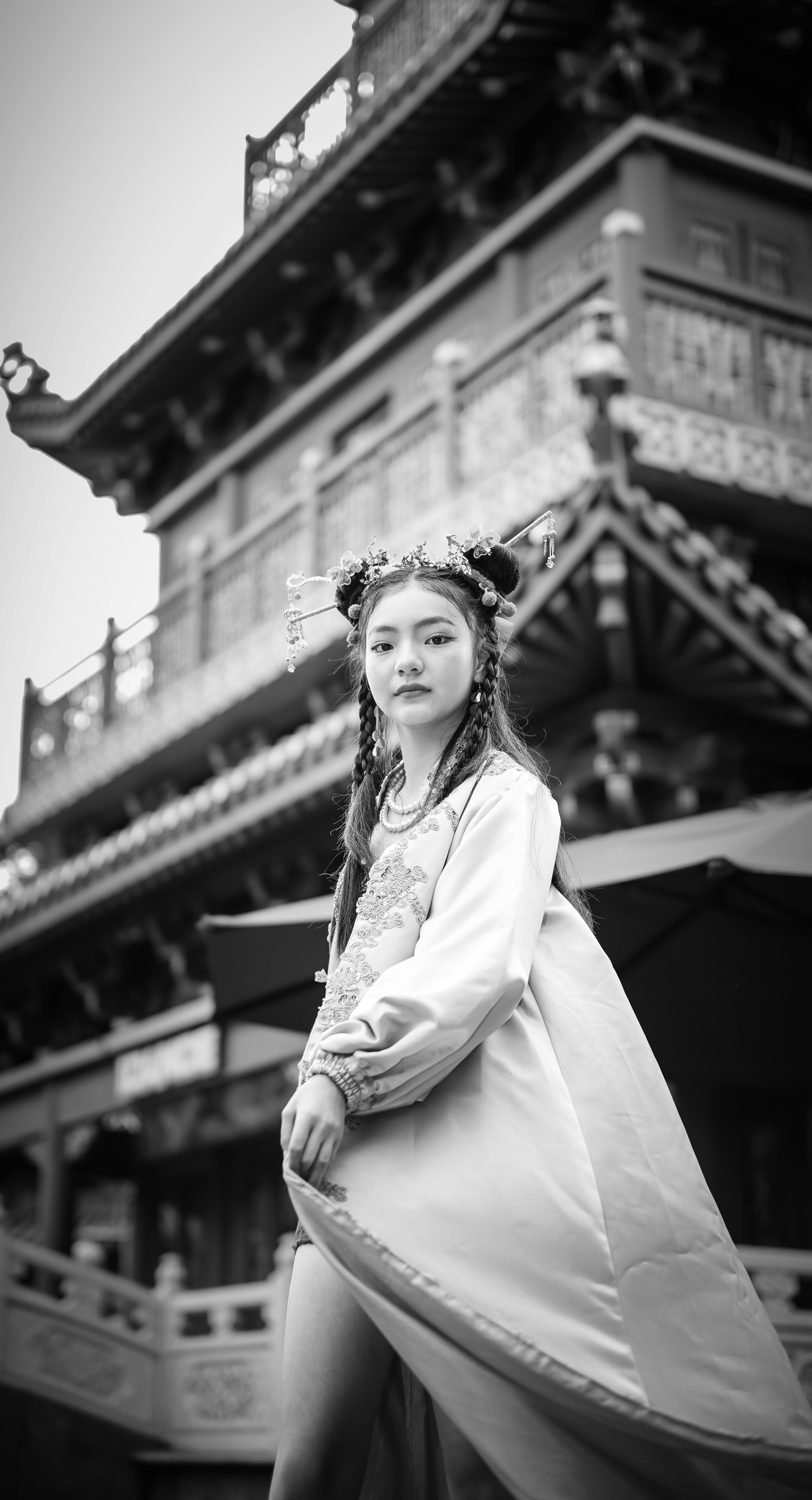 bezplatná Krásný asijský model v tradičním oděvu s úchvatným pozadím architektury v černé a bílé. Základová fotografie