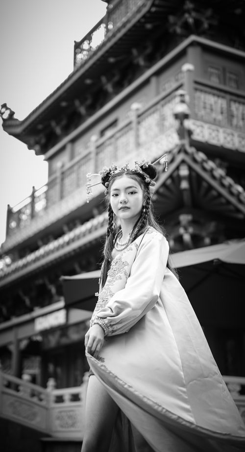 Free Beautiful Asian model in traditional dress with stunning architecture backdrop in black and white. Stock Photo