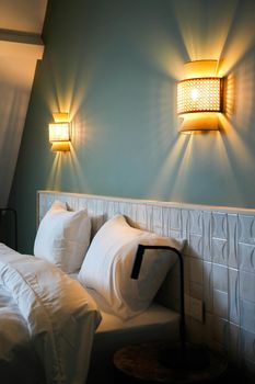 Warm and inviting bedroom illuminated by stylish wall sconces, perfect for relaxation.