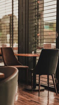 A serene cafe interior featuring modern seating and large windows, perfect for work or relaxation.