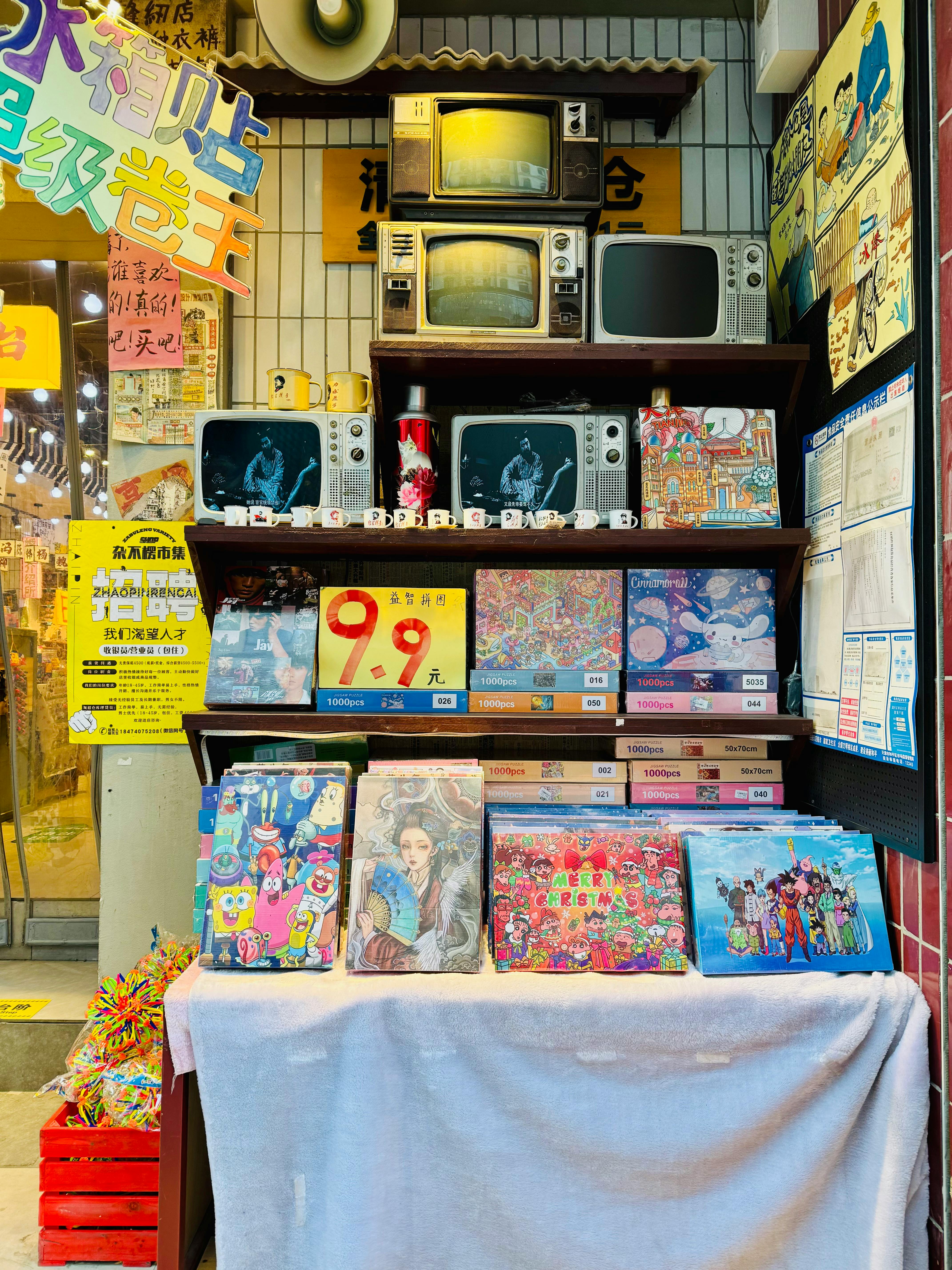 Colorful display of vintage TVs and board games in a vibrant retail setting.