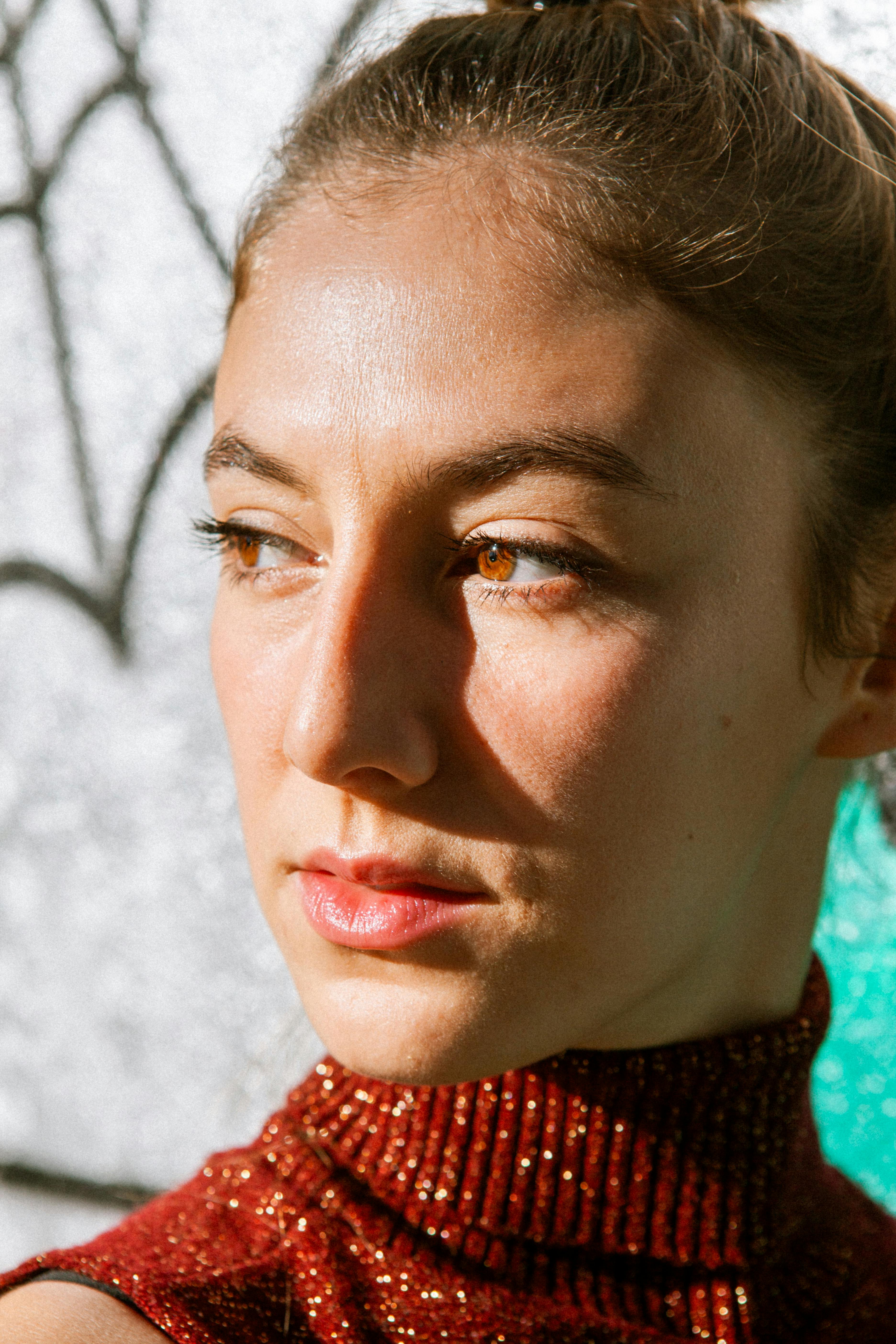 Artistic close-up portrait of a woman with a blurred background and dramatic lighting.