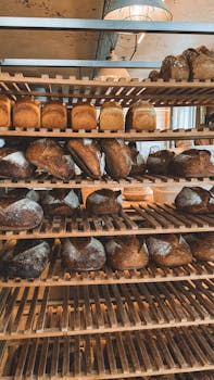 A selection of freshly baked artisan breads displayed on wooden shelves.