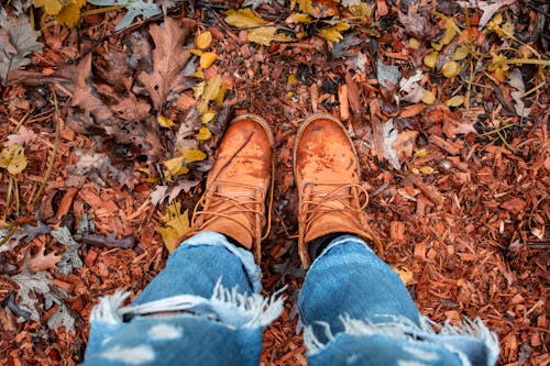 Free Person Wearing Distressed Blue Denim Jeans and Brown Leather Boots Standing Stock Photo