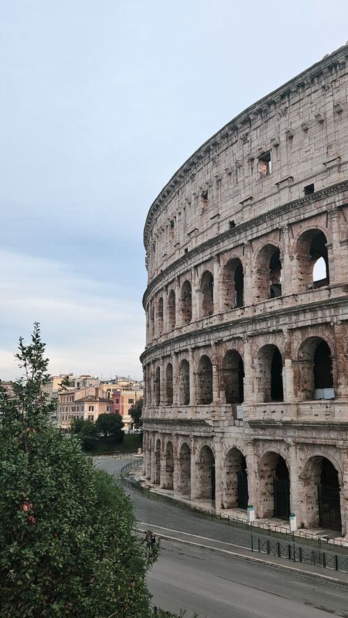 Free Historic Colosseum amidst Rome's architecture under a clear blue sky. Stock Photo