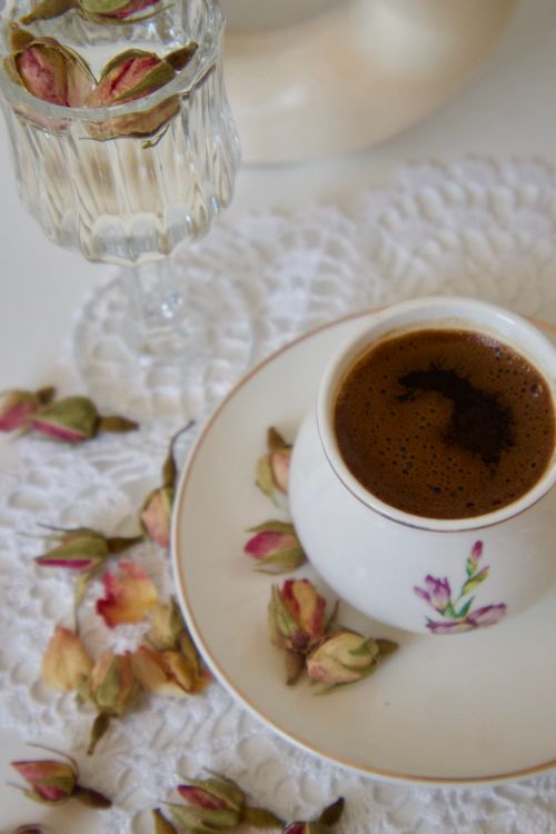 Free Turkish coffee served with dried rosebuds and lace tablecloth. Stock Photo