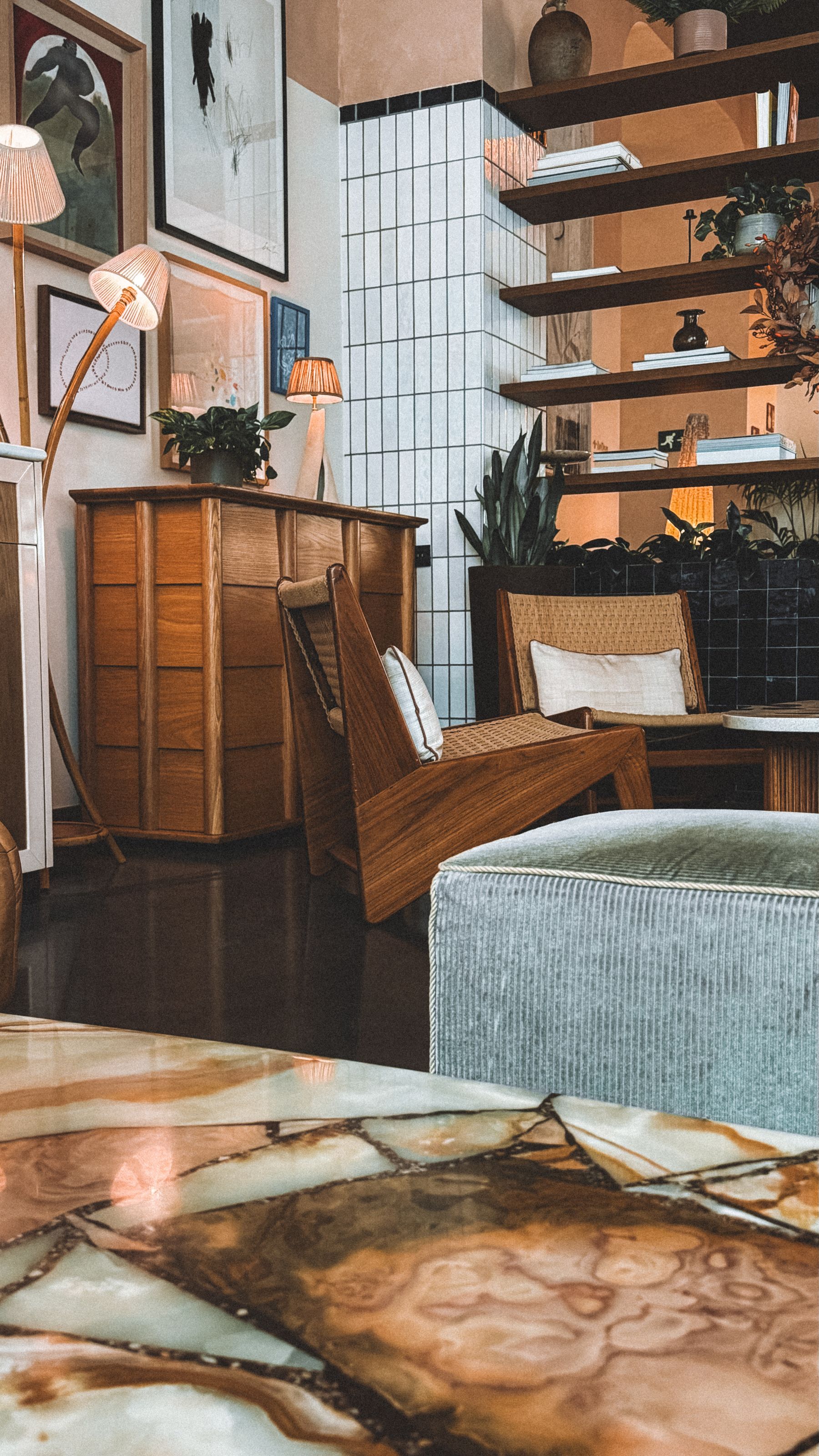 Edited living room with warm wood furniture, upholstered seating, rug and controlled decorative layers