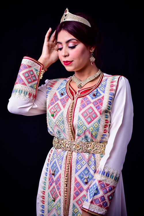 Free Woman in vibrant Moroccan caftan with intricate patterns and jewelry. Stock Photo