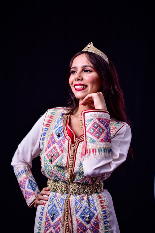 Free A smiling woman in traditional Moroccan dress and tiara posing confidently. Stock Photo