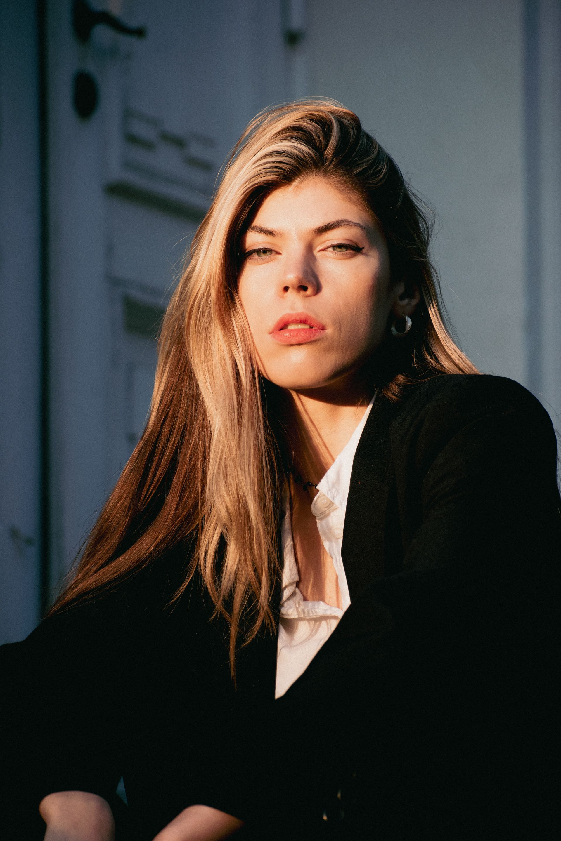 A striking portrait of a woman in natural light, exuding confidence and elegance in a stylish setting.