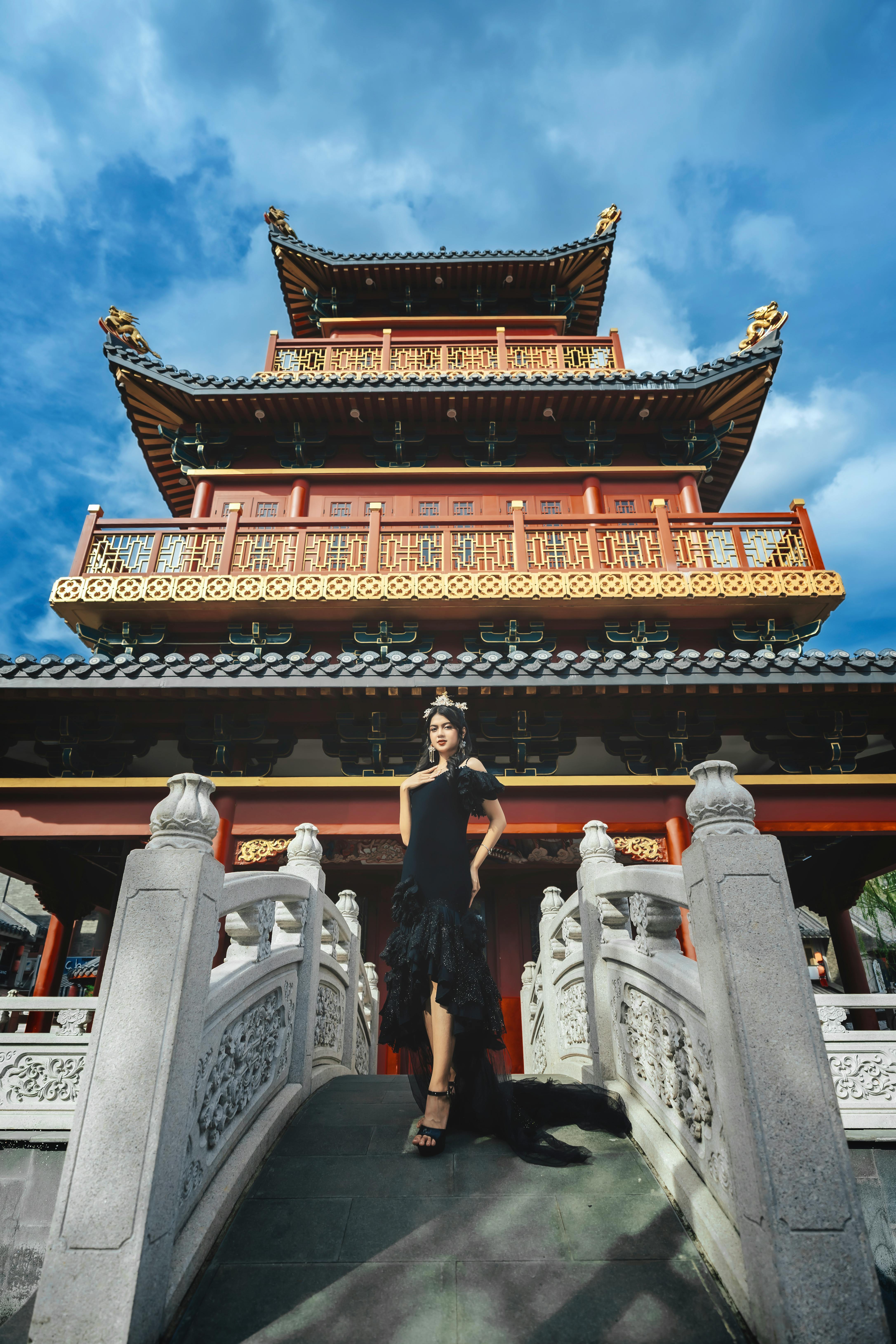 elegant woman posing by traditional pagoda