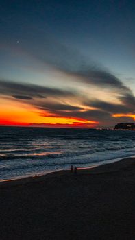Stunning sunset over Kamakura beach, Japan, with vivid colors and ocean waves.