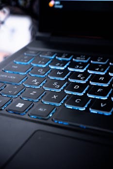 A detailed image of a backlit laptop keyboard with blue lighting creating a modern tech vibe.