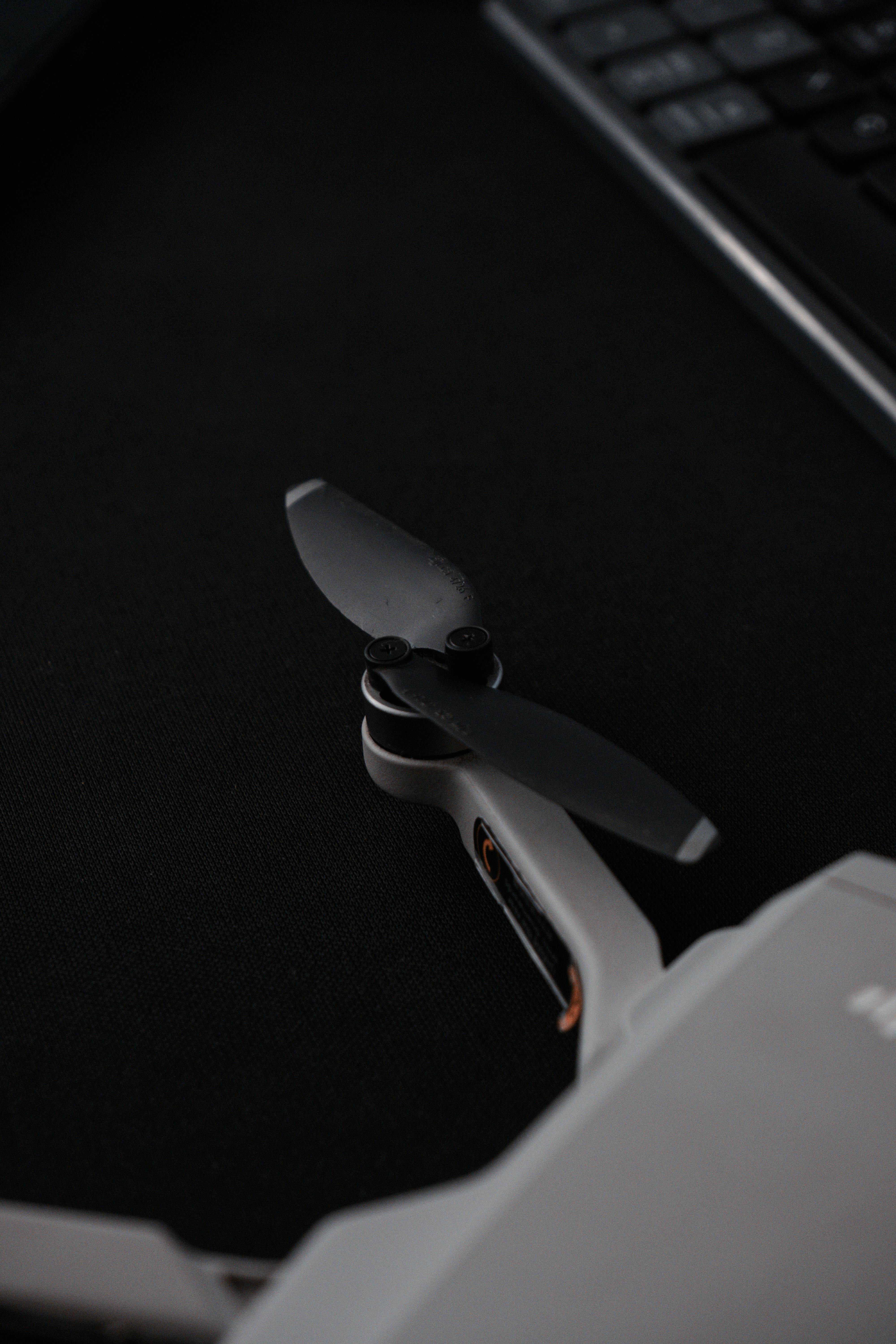Detailed close-up of a drone's propeller on a dark background near a keyboard.