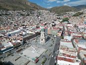 Aerial shot of Torre del Reloj in Pachuca, highlighting the vibrant cityscape and surrounding mountains.