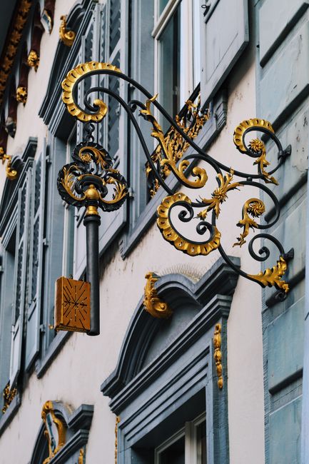 Intricate ironwork and decorations on a Swiss building facade showcasing classic architectural elegance.