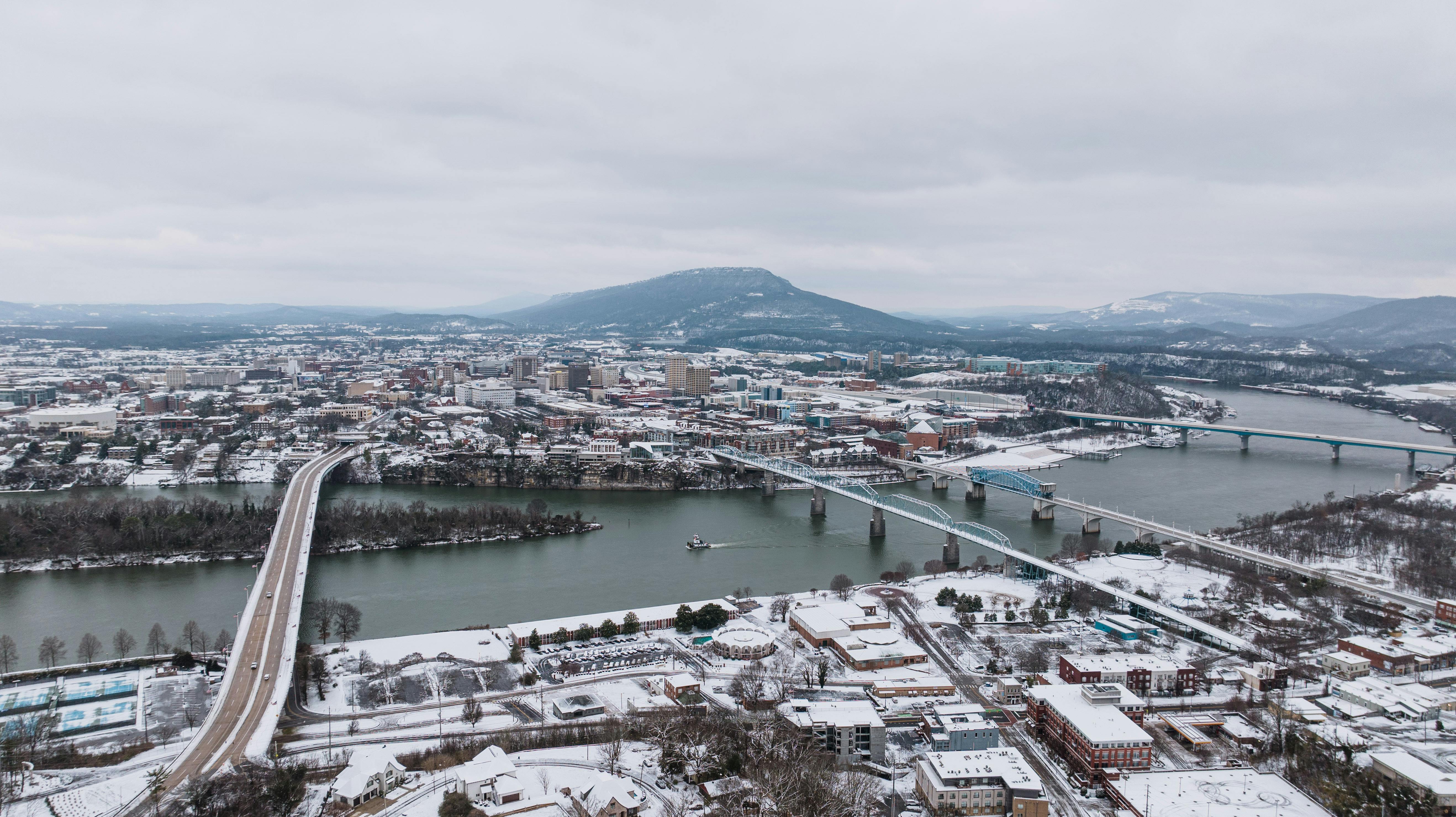 Aerial perspective of snowy Chattanooga, TN showcasing bridges over the Tennessee River.