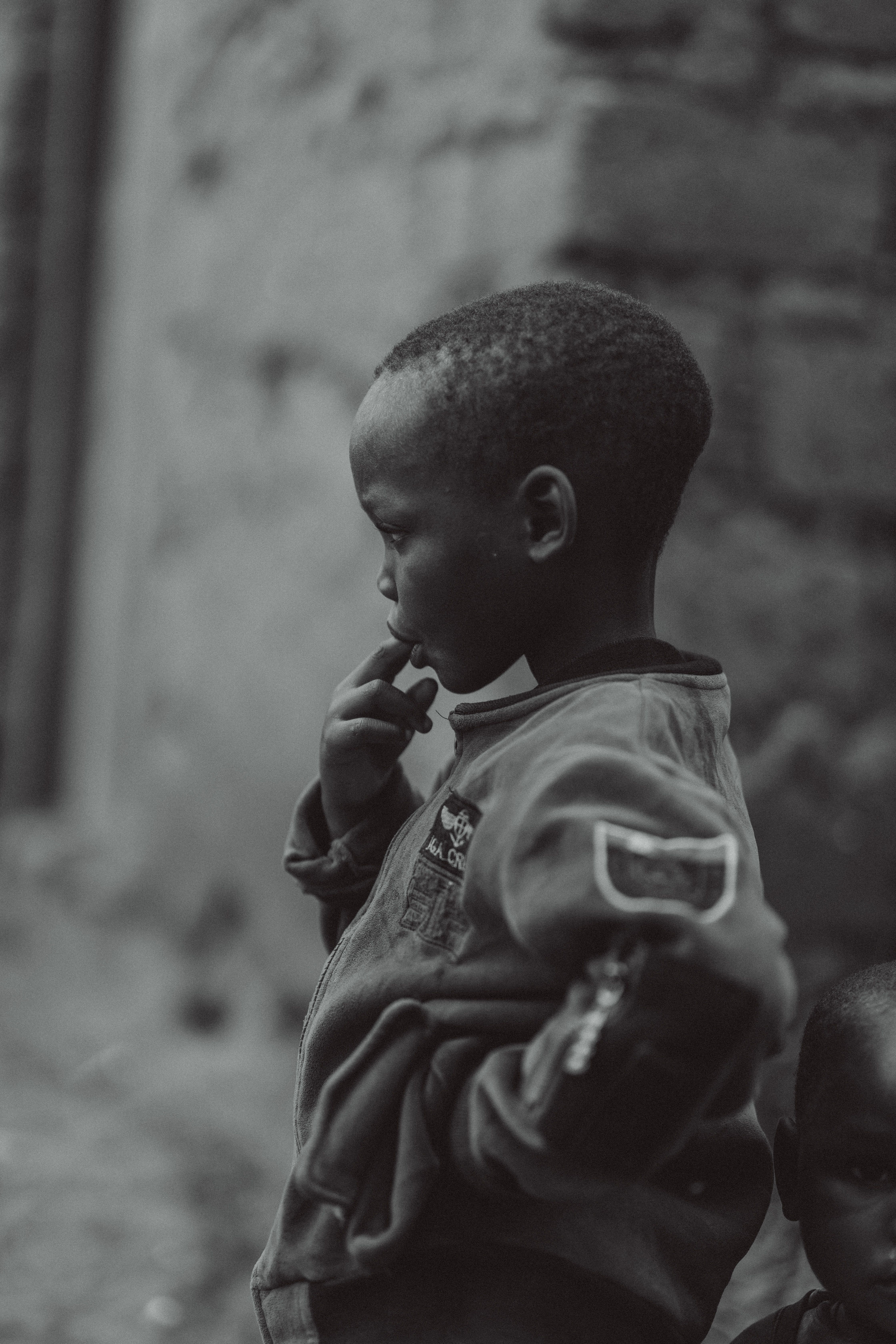 Contemplative Child in Bujumbura Street Scene · Free Stock Photo