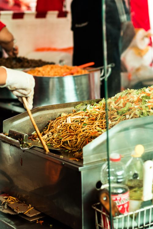 Free Street food stall in São Paulo with vendor cooking noodles in vibrant outdoor setting. Stock Photo
