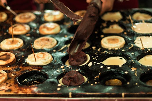 Close-up of sweet pastries being prepared on a hot griddle in São Paulo street market.