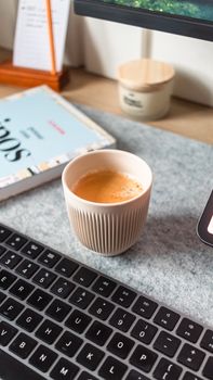 A stylish minimalist workspace featuring a coffee cup beside a keyboard.