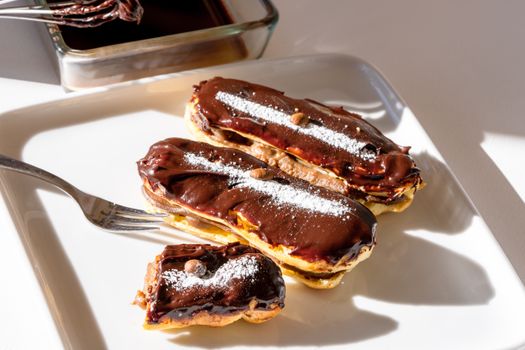 Tempting homemade eclairs topped with rich chocolate icing, a true French delicacy.