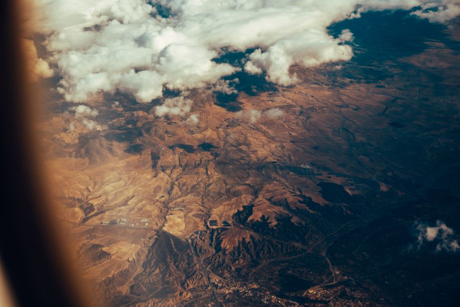 Stunning aerial view showcasing clouds hovering over a dry, rugged landscape.