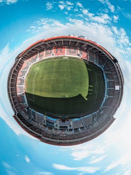 Unique fish-eye aerial view of a large, empty soccer stadium.