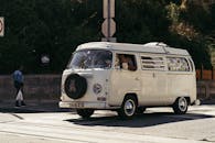 一辆经典的大众露营车停在城市街道上，营造出复古的感觉