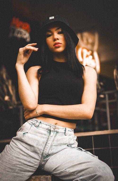 Free Stylish young woman poses confidently in casual streetwear and bucket hat. Stock Photo