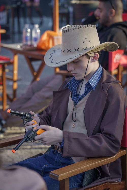 Free Young adult in a cowboy costume with toy guns at a Buenos Aires convention. Stock Photo
