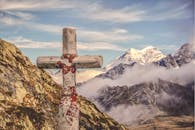 云雾笼罩的惊人山峰中，矗立着一座饱经风霜的石十字架