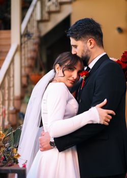 Bride and groom embrace in a touching outdoor wedding moment.