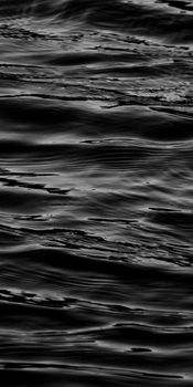 A serene black and white abstract capture of water waves creating fluid textures.