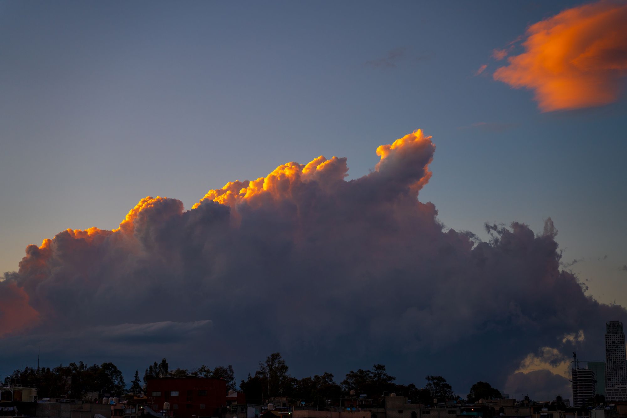 A dramatic cloud formation at sunset over Ciudad de México, creating a vibrant and moody sky.