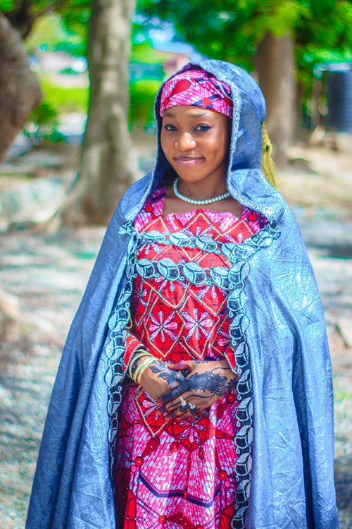 Free Smiling woman in colorful traditional attire with henna, outdoors. Stock Photo