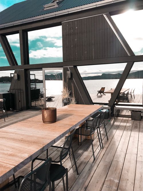Free Cozy modern deck with dining area overlooking a serene lakeside view. Stock Photo