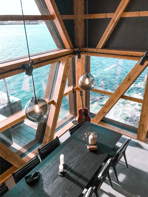 A spacious dining area with panoramic lake view in a modern cabin.