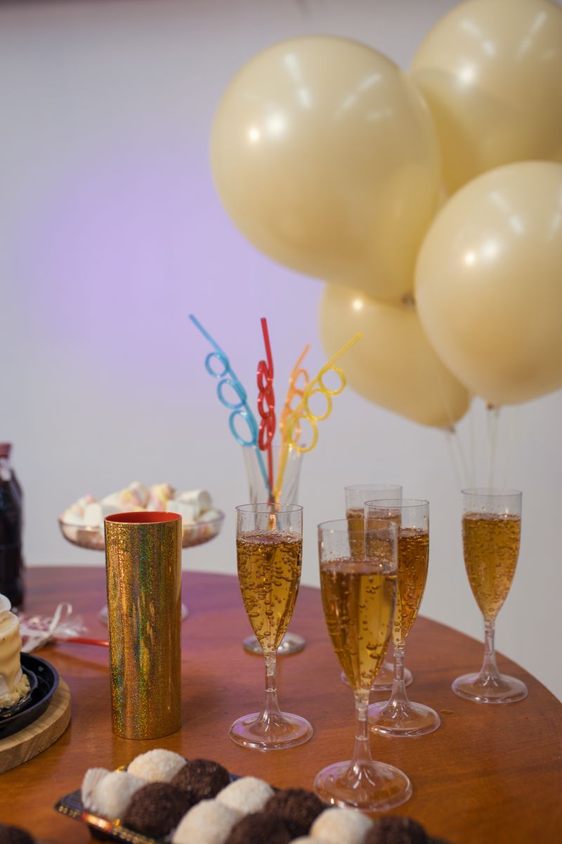 Elegant celebration setup with champagne glasses and balloons in warm tones