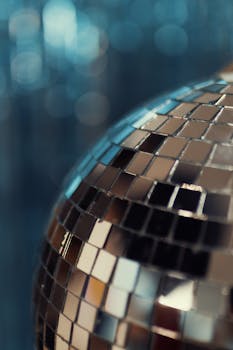 A sparkling disco ball creates a vibrant atmosphere with defocused background lights.