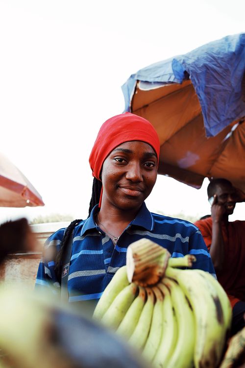 Free A vendor in Abuja, Nigeria, showcasing fresh bananas at an outdoor market. Stock Photo